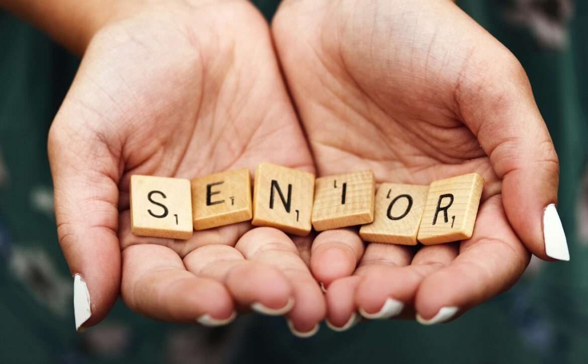 Senior dice on person's palm