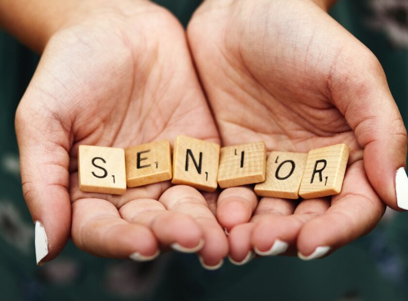 Senior dice on person's palm