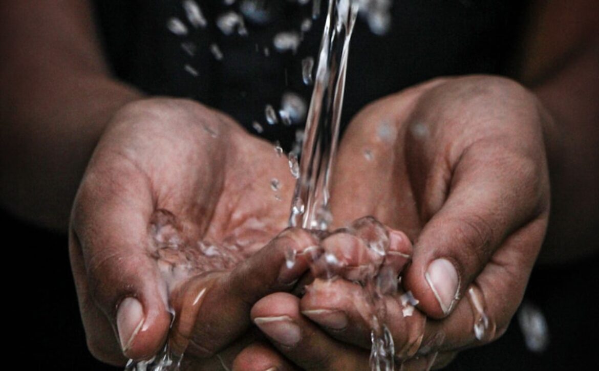 pouring water on person's hands