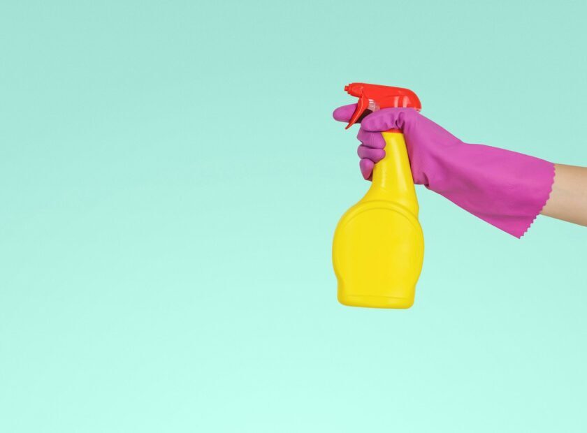 person holding yellow plastic spray bottle