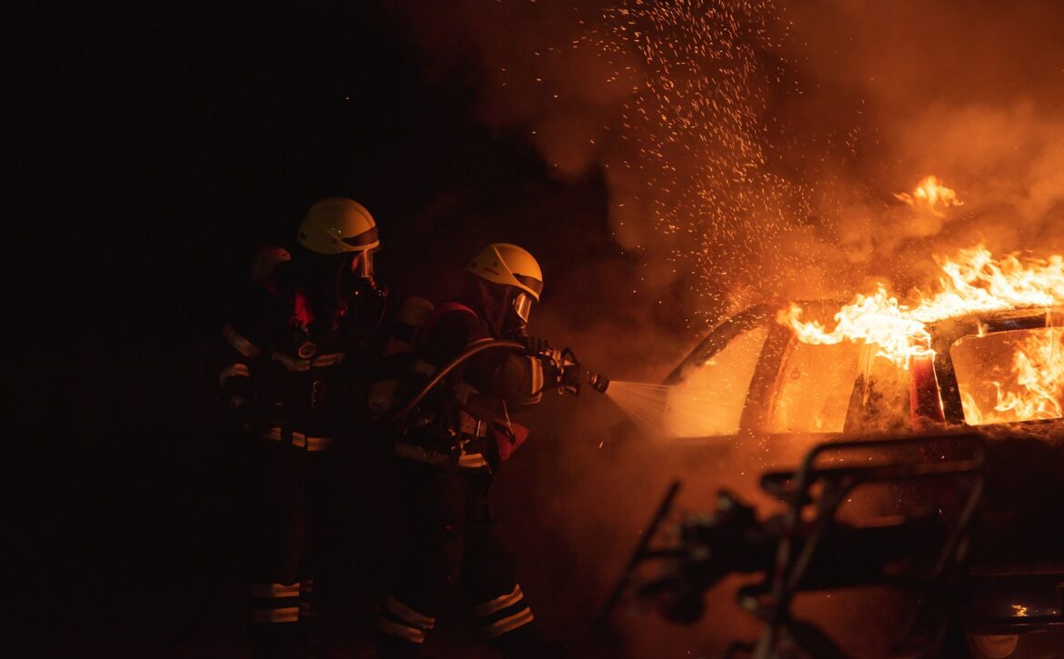 2 men in black helmet standing near fire
