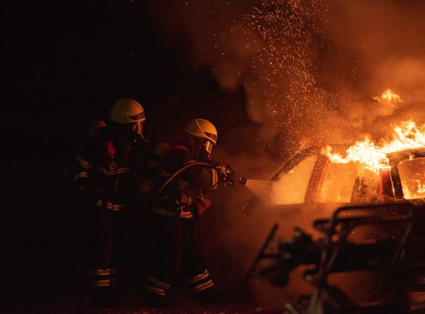 2 men in black helmet standing near fire