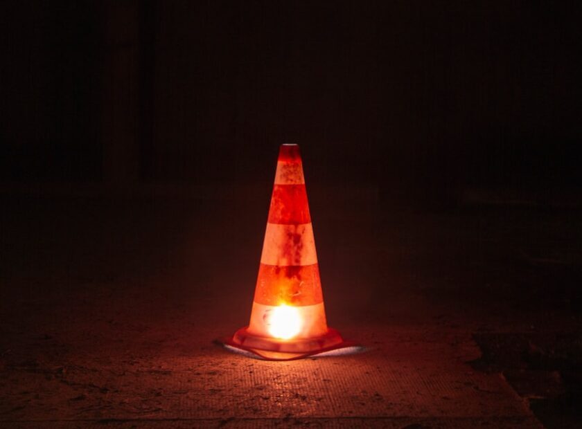 A traffic cone sitting on the ground at night