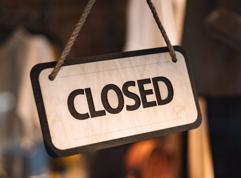 A close up of a closed sign hanging from a rope